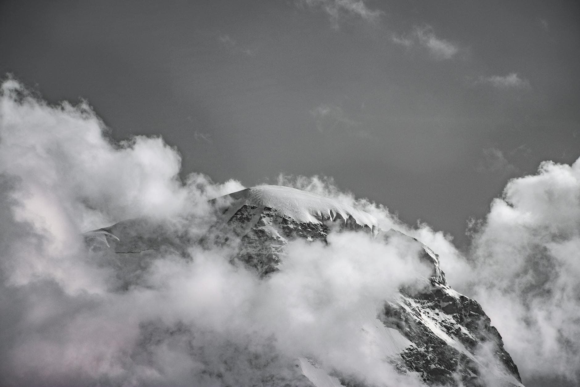 Dramatic snow mountain peak casting shadows in deep twilight