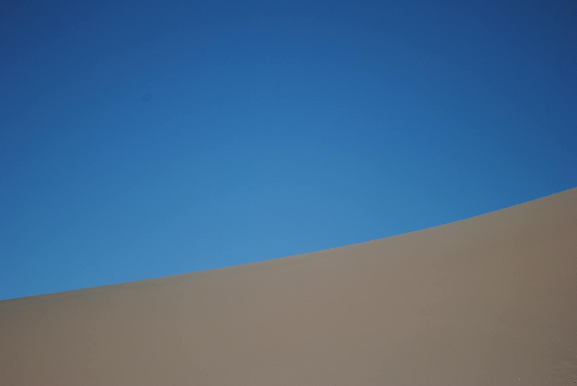 Stark and minimal desert dune meeting the flat horizon